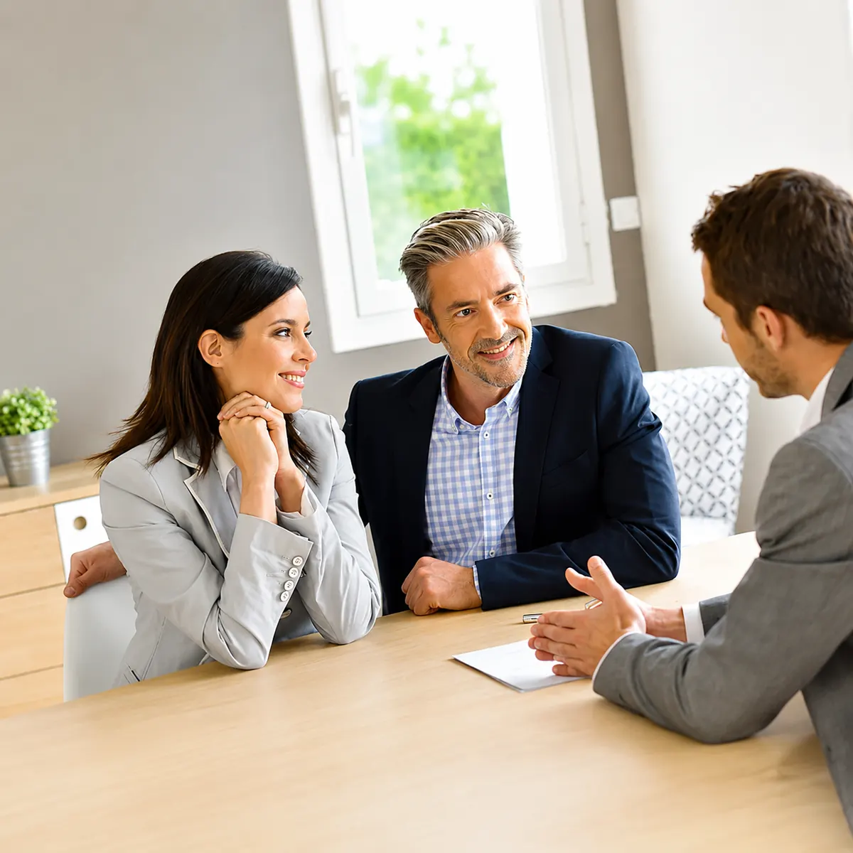 Couple souriant en rendez-vous avec un conseiller BNP PARIBAS pour une aide professionnelle
